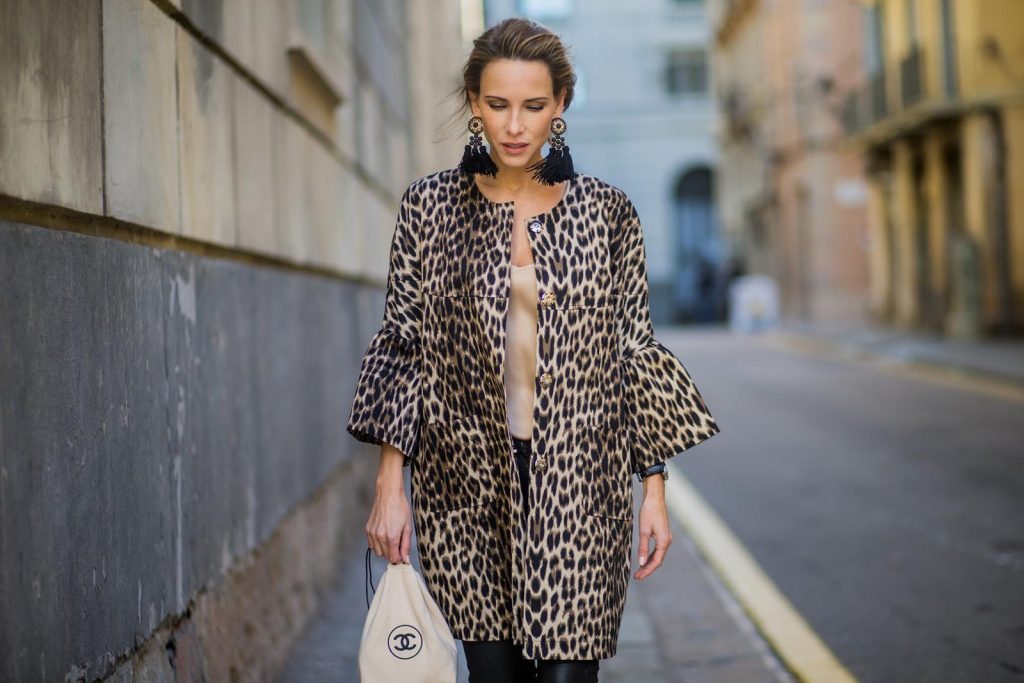 BARCELONA, SPAIN - NOVEMBER 29: Take a walk on the wild side, Alexandra Lapp wearing an animal printed jacket with voluminous bell sleeves by Steffen Schraut, a straight cut silk top in light gold, black skinny leather pants from Current Elliott, sand-black Chanel Mules in suede, black Tassel Earrings by Farina for NA-KD and tote bag in beige from Chanel with Chanel logo on November 29, 2017 in Barcelona, Spain.