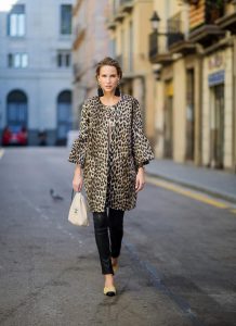 BARCELONA, SPAIN - NOVEMBER 29: Take a walk on the wild side, Alexandra Lapp wearing an animal printed jacket with voluminous bell sleeves by Steffen Schraut, a straight cut silk top in light gold, black skinny leather pants from Current Elliott, sand-black Chanel Mules in suede, black Tassel Earrings by Farina for NA-KD and tote bag in beige from Chanel with Chanel logo on November 29, 2017 in Barcelona, Spain.