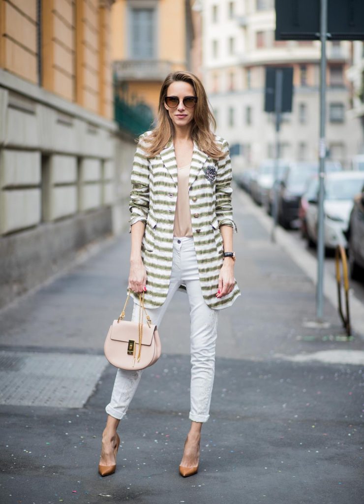 Alexandra Lapp wearing a striped blazer in green and white and white pants with gold sprinkles from Airfield, a camel tone satin top by Jadicted, a pastel pink handbag from Chloe with a gold buckle and chain, camel tone pumps by Christian Louboutin and cat-eye shaped sunglasses in black with a gold rim from Maison Mavada seen during Milan Fashion Week Fall/Winter 2018/19 on February 21, 2018 in Milan, Italy.