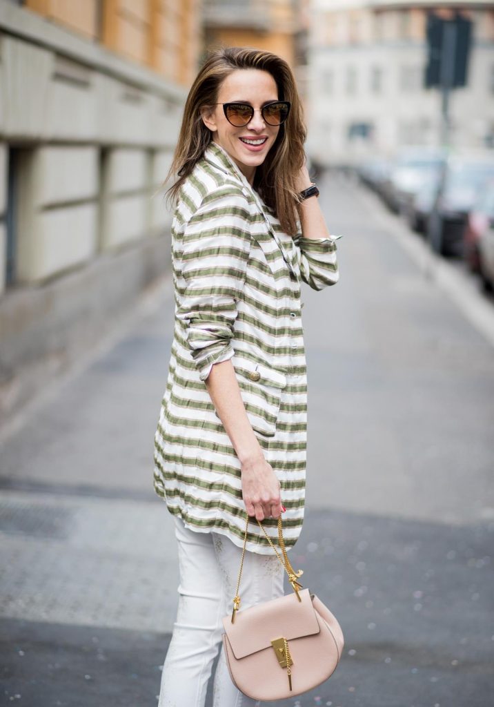 Alexandra Lapp wearing a striped blazer in green and white and white pants with gold sprinkles from Airfield, a camel tone satin top by Jadicted, a pastel pink handbag from Chloe with a gold buckle and chain, camel tone pumps by Christian Louboutin and cat-eye shaped sunglasses in black with a gold rim from Maison Mavada seen during Milan Fashion Week Fall/Winter 2018/19 on February 21, 2018 in Milan, Italy.