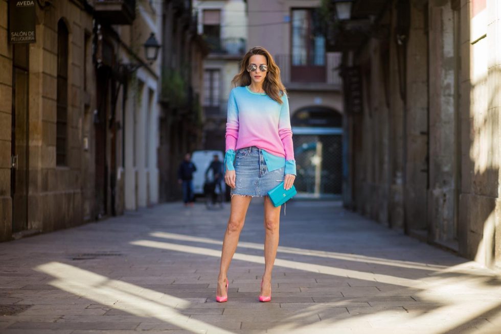 Alexandra Lapp wearing shades of pastels, a mini jeans skirt from Levis, batik cashmere pullover from Heartbreaker in turquoise and pink, Equipment silk blouse in turquoise, little purse bag from Chanel with golden Chanel sign, silver mirrored sunglasses from Le Specs and pink patent So Kate heels from Christian Louboutin on November 28, 2017 in Barcelona, Spain.