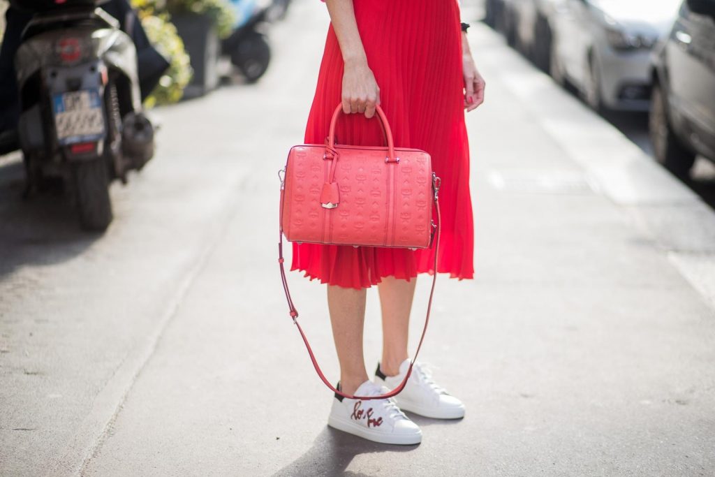 MILAN, ITALY - FEBRUARY 21: Model and Blogger Alexandra Lapp wearing pink and red, a red pleated skirt fro SET, pink cashmere pullover from Jadicted, sneakers from Steffen Schraut, Audrey sunglasses in black from Céline and Boston bag in red from MCM during Milan Fashion Week Fall/Winter 2018/19 on February 21, 2018 in Milan, Italy.