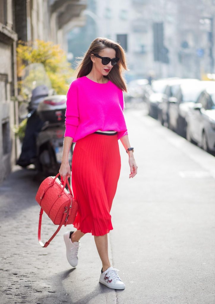 MILAN, ITALY - FEBRUARY 21: Model and Blogger Alexandra Lapp wearing pink and red, a red pleated skirt fro SET, pink cashmere pullover from Jadicted, sneakers from Steffen Schraut, Audrey sunglasses in black from Céline and Boston bag in red from MCM during Milan Fashion Week Fall/Winter 2018/19 on February 21, 2018 in Milan, Italy.
