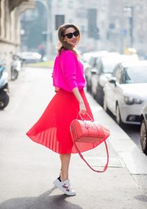 MILAN, ITALY - FEBRUARY 21: Model and Blogger Alexandra Lapp wearing pink and red, a red pleated skirt fro SET, pink cashmere pullover from Jadicted, sneakers from Steffen Schraut, Audrey sunglasses in black from Céline and Boston bag in red from MCM during Milan Fashion Week Fall/Winter 2018/19 on February 21, 2018 in Milan, Italy.