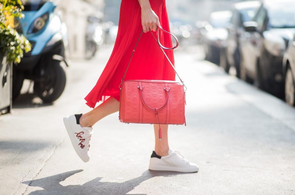 MILAN, ITALY - FEBRUARY 21: Model and Blogger Alexandra Lapp wearing pink and red, a red pleated skirt fro SET, pink cashmere pullover from Jadicted, sneakers from Steffen Schraut, Audrey sunglasses in black from Céline and Boston bag in red from MCM during Milan Fashion Week Fall/Winter 2018/19 on February 21, 2018 in Milan, Italy.