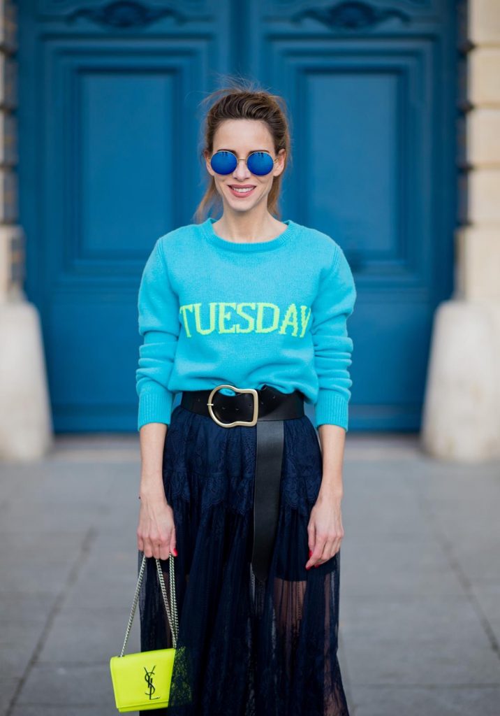 Alexandra Lapp wearing a turquoise pullover with a neon print Tuesday by Alberta Ferretti, a playful dress in black floral lace from Self-Portrait, black waist belt with big buckle from Dorothee Schumacher, blue mirrored sunglasses from Mykita, neon yellow pumps from Christian Louboutin and matching neon yellow handbag from Yves Saint Laurent is seen on February 28, 2018 in Paris, France.