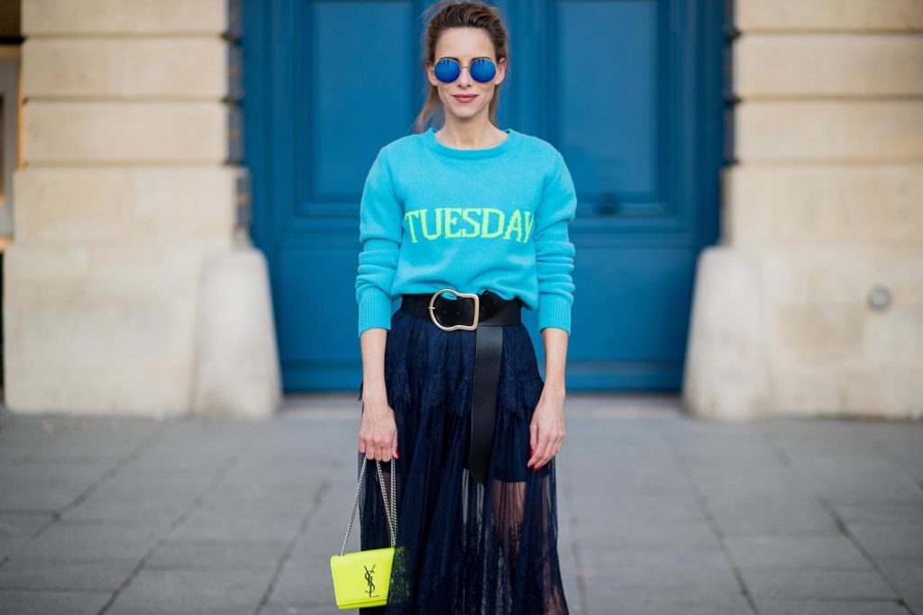 Alexandra Lapp wearing a turquoise pullover with a neon print Tuesday by Alberta Ferretti, a playful dress in black floral lace from Self-Portrait, black waist belt with big buckle from Dorothee Schumacher, blue mirrored sunglasses from Mykita, neon yellow pumps from Christian Louboutin and matching neon yellow handbag from Yves Saint Laurent is seen on February 28, 2018 in Paris, France.