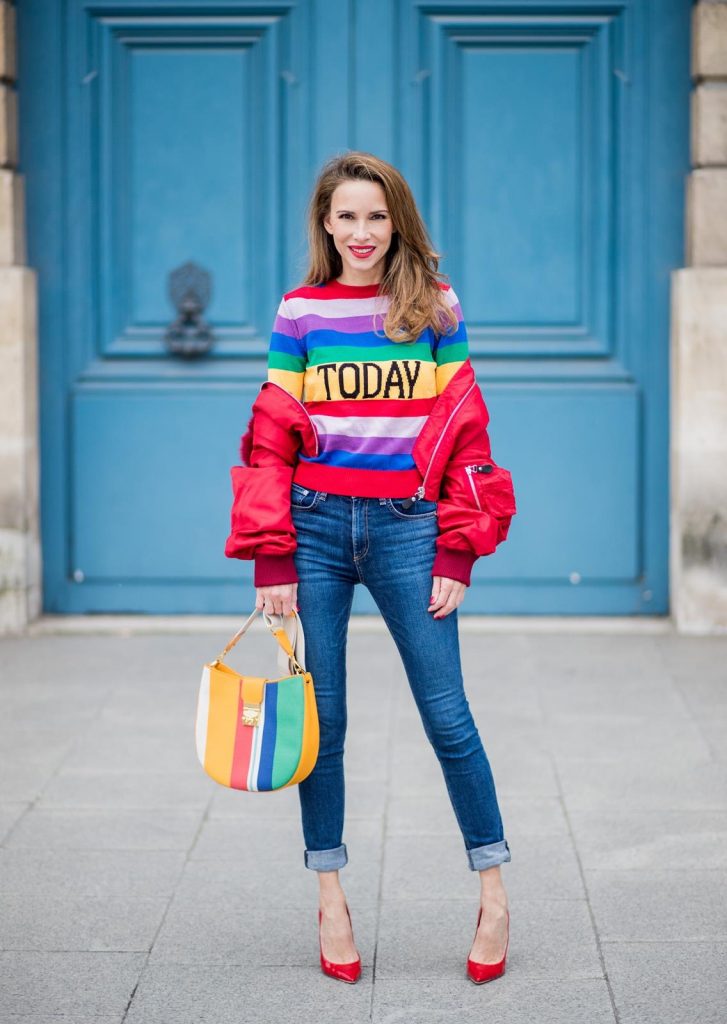 PARIS, FRANCE - FEBRUARY 28: Alexandra Lapp wearing Pullover Alberta Ferretti with today print, AG Jeans denim, Bag MCM Patricia Hobo bag in striped Canvas, Aviator Sunglasses in green from Ray Ban, Heels Gianvito Rossi in patent red, jacket Yves Salomon is seen on February 28, 2018 in Paris, France.