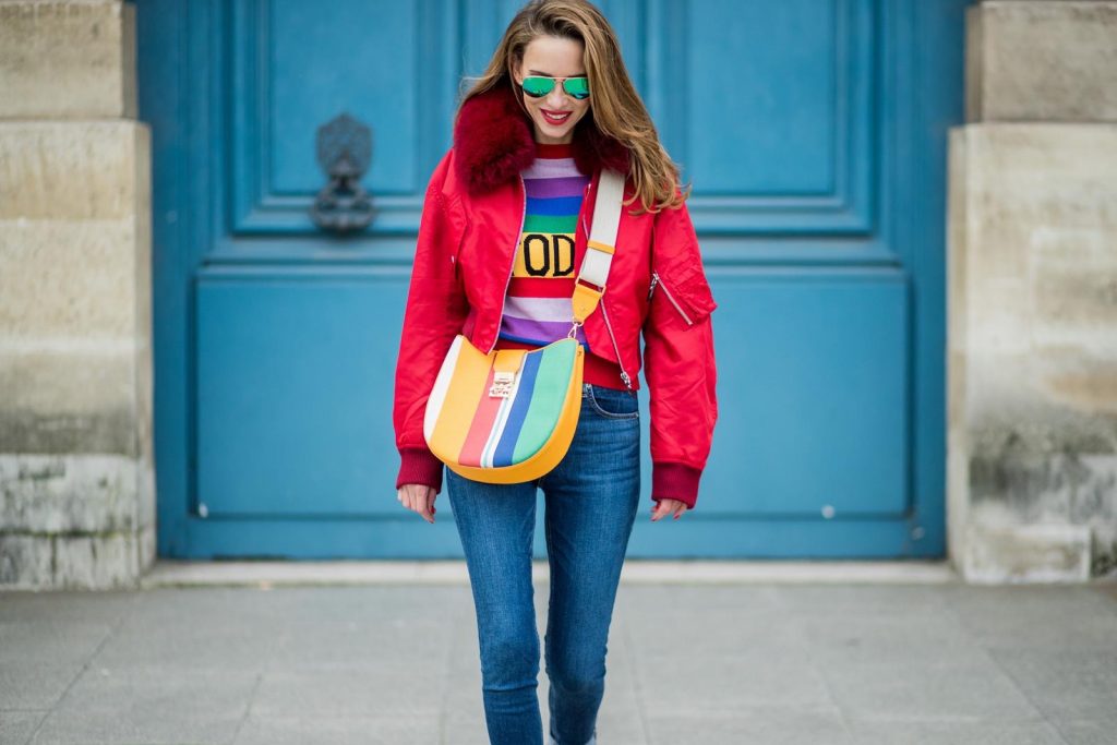 PARIS, FRANCE - FEBRUARY 28: Alexandra Lapp wearing Pullover Alberta Ferretti with today print, AG Jeans denim, Bag MCM Patricia Hobo bag in striped Canvas, Aviator Sunglasses in green from Ray Ban, Heels Gianvito Rossi in patent red, jacket Yves Salomon is seen on February 28, 2018 in Paris, France.