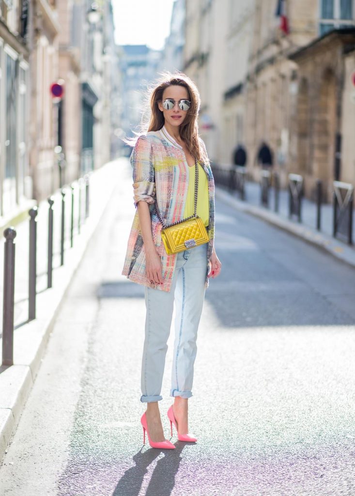 PARIS, FRANCE - MARCH 02: Alexandra Lapp wearing pastel tweed, a long tweed blazer in pastel colors from Airfield, a silk top in bright yellow from Jadicted, light blue boyfriend jeans by Airfield, a neon yellow Chanel bag, neon pink high heels from Christian Louboutin and sunglasses from Le Specs is seen on March 2, 2018 in Paris, France.