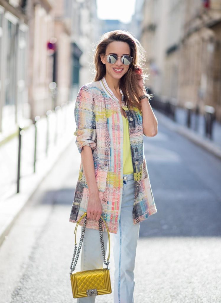 PARIS, FRANCE - MARCH 02: Alexandra Lapp wearing pastel tweed, a long tweed blazer in pastel colors from Airfield, a silk top in bright yellow from Jadicted, light blue boyfriend jeans by Airfield, a neon yellow Chanel bag, neon pink high heels from Christian Louboutin and sunglasses from Le Specs is seen on March 2, 2018 in Paris, France.