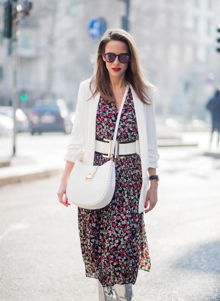 Alexandra Lapp wearing a long flower dress from H&M, silver shiny boots by H&M, a long white blazer from Zara, a lacquer waist belt in white and black from Balmain, a white Patricia Hobo bag with studs and sunglasses from Le Specs in pink seen during Milan Fashion Week Fall/Winter 2018/19 on February 21, 2018 in Milan, Italy.