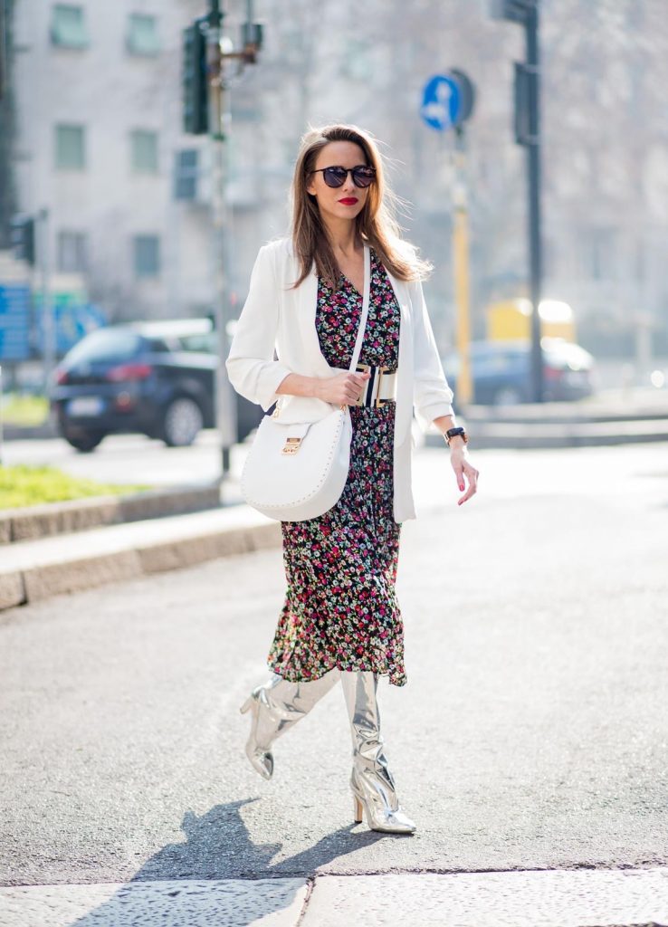 Alexandra Lapp wearing a long flower dress from H&M, silver shiny boots by H&M, a long white blazer from Zara, a lacquer waist belt in white and black from Balmain, a white Patricia Hobo bag with studs and sunglasses from Le Specs in pink seen during Milan Fashion Week Fall/Winter 2018/19 on February 21, 2018 in Milan, Italy.