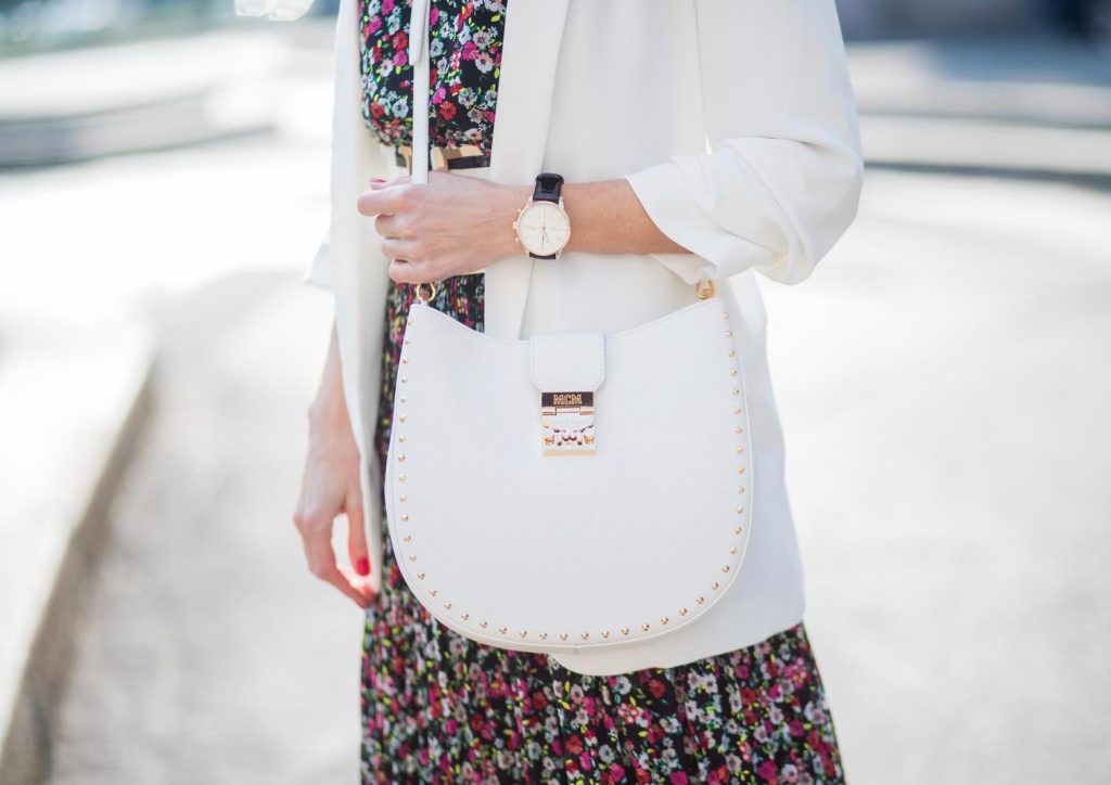 Alexandra Lapp wearing a long flower dress from H&M, silver shiny boots by H&M, a long white blazer from Zara, a lacquer waist belt in white and black from Balmain, a white Patricia Hobo bag with studs and sunglasses from Le Specs in pink seen during Milan Fashion Week Fall/Winter 2018/19 on February 21, 2018 in Milan, Italy.