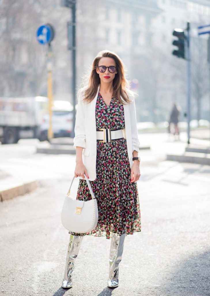 Alexandra Lapp wearing a long flower dress from H&M, silver shiny boots by H&M, a long white blazer from Zara, a lacquer waist belt in white and black from Balmain, a white Patricia Hobo bag with studs and sunglasses from Le Specs in pink seen during Milan Fashion Week Fall/Winter 2018/19 on February 21, 2018 in Milan, Italy.