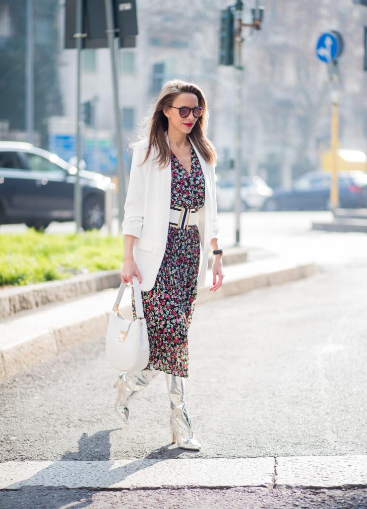 Alexandra Lapp wearing a long flower dress from H&M, silver shiny boots by H&M, a long white blazer from Zara, a lacquer waist belt in white and black from Balmain, a white Patricia Hobo bag with studs and sunglasses from Le Specs in pink seen during Milan Fashion Week Fall/Winter 2018/19 on February 21, 2018 in Milan, Italy.