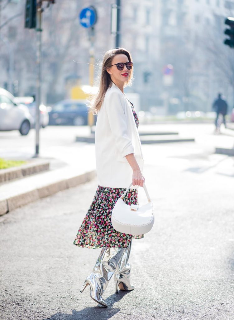 Alexandra Lapp wearing a long flower dress from H&M, silver shiny boots by H&M, a long white blazer from Zara, a lacquer waist belt in white and black from Balmain, a white Patricia Hobo bag with studs and sunglasses from Le Specs in pink seen during Milan Fashion Week Fall/Winter 2018/19 on February 21, 2018 in Milan, Italy.