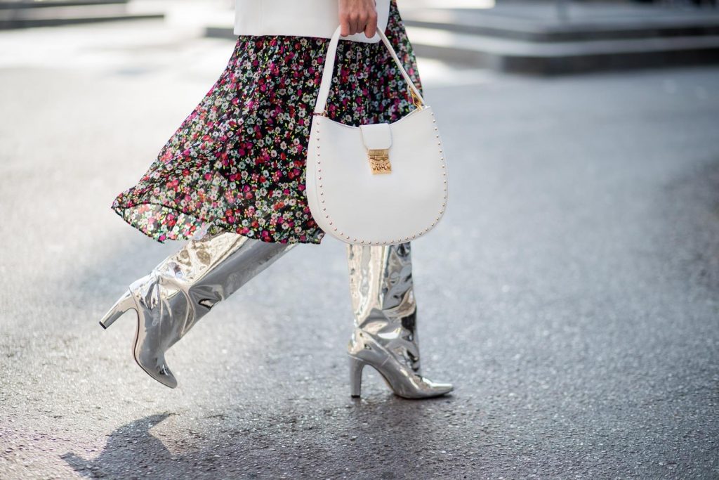 Alexandra Lapp wearing a long flower dress from H&M, silver shiny boots by H&M, a long white blazer from Zara, a lacquer waist belt in white and black from Balmain, a white Patricia Hobo bag with studs and sunglasses from Le Specs in pink seen during Milan Fashion Week Fall/Winter 2018/19 on February 21, 2018 in Milan, Italy.