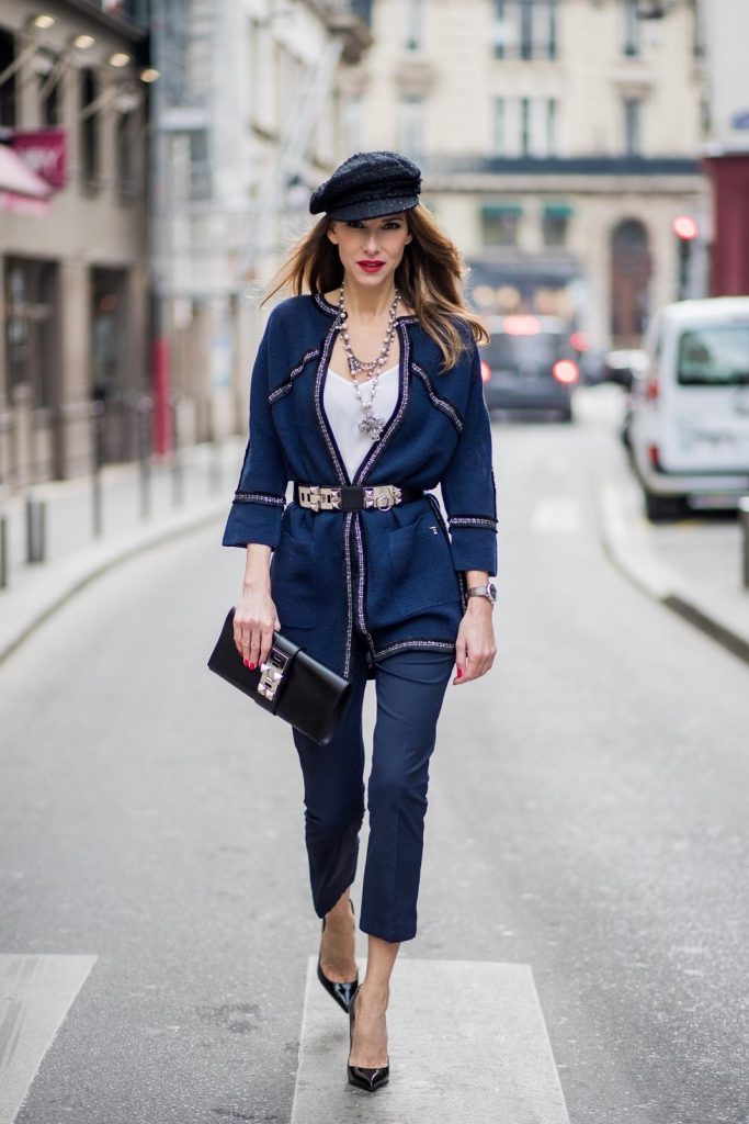 Alexandra Lapp wearing silver stitches: dark blue cropped pants and blazer shaped cardigan from Airfield, So Kate heels in patent black Christian Loubboutin, white silk top from Jadicted, bakerboy cap and pearl necklace from Chanel, Collier de Chien belt and clutch in black from Hermes, IWC watch is seen during Paris Fashion Week Womenswear Fall/Winter 2018/2019 on March 3, 2018 in Paris, France.