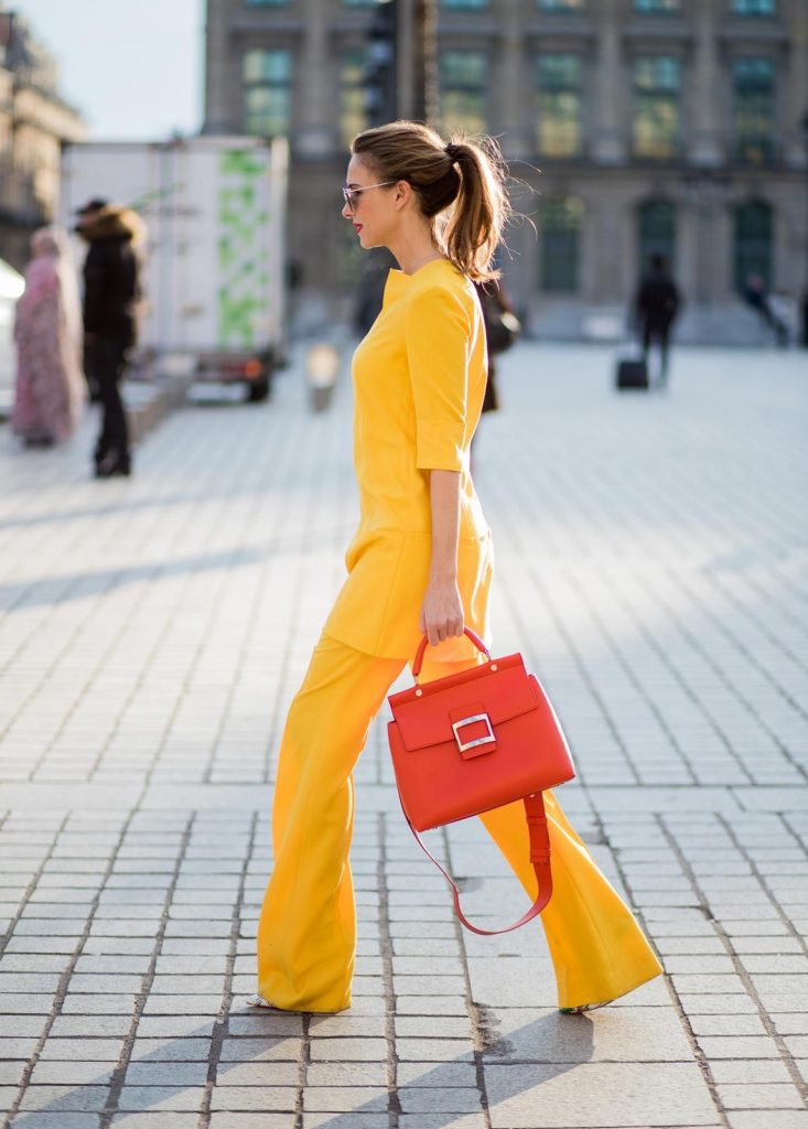 Alexandra Lapp wearing taroni silk pants & a tunic in yellow from Talbot & Runhof, small Viv Cabas in orange with shoulder strap, mirrored sunglasses from Le Specs and Christian Louboutin So Kate Pumps is seen on February 28, 2018 in Paris, France.