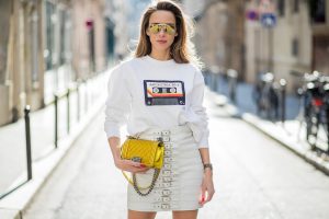 Alexandra Lapp in Think White: she is seen wearing a white leather miniskirt from Manokhi, Selfmade Sweater from Wodka Ogurez, Yves Salomon fur veste in white, Aldo heels with red lips, vintage Ray-ban in yellow and a boy bag from Chanel in gold during Paris Fashion Week Womenswear Fall/Winter 2018/2019 on March 5, 2018 in Paris, France.