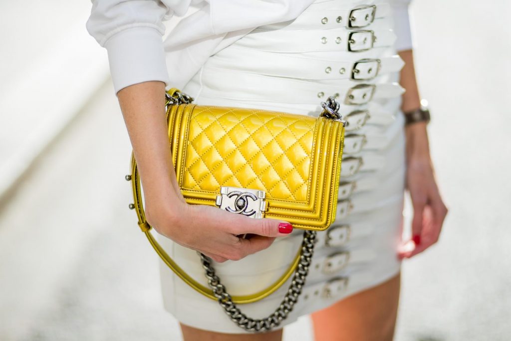 Alexandra Lapp in Think White: she is seen wearing a white leather miniskirt from Manokhi, Selfmade Sweater from Wodka Ogurez, Yves Salomon fur veste in white, Aldo heels with red lips, vintage Ray-ban in yellow and a boy bag from Chanel in gold during Paris Fashion Week Womenswear Fall/Winter 2018/2019 on March 5, 2018 in Paris, France.