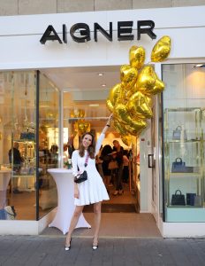 #AIGNERLOVE - Bonn, May 2018, Model and Blogger Alexandra Lapp at the re-opening Aigner store in Bonn, wearing an Alaïa dress in white, black an white Saint Laurent pumps and the it-bag Aigner Candice bag S in pink with black and white combined with the Love shoulder strap.