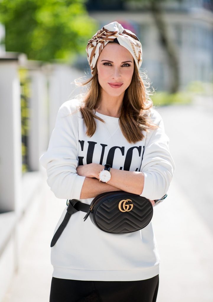 Alexandra Lapp wearing a Gucci Belt Bag Look with a white crew-neck cotton sweatshirt by Gucci, black double layered lace skirt by Zara , the black GG Marmont matelasse belt bag in black, black white striped So Kate pumps by Christian Louboutin, a vintage print silk scarf turban by Gucci, Portugieser watch by IWC and black Celine Audrey sunglasses on May 5, 2018 in Duesseldorf, Germany.