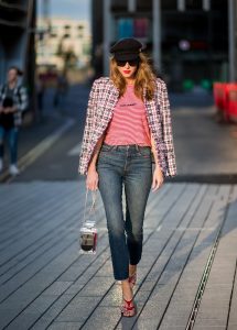 Alexandra Lapp wearing a striped shirt look with Saint Laurent Logo jersey T-Shirt in red-white, a white/blue/red Tweed Jacket by Balmain, dark blue Levis Super Skinny jeans, Prada flame shoes, the Chanel Perfume Bottle Bag in clear plexiglass, vintage Chanel Bakerboy cap and black Celine sunglasses on May 3, 2018 in Duesseldorf, Germany.