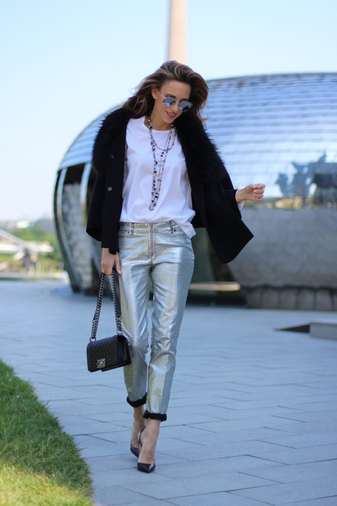 Model and Blogger Alexandra Lapp wearing silver denim pants from Airfield, black knit and fur cape from Airfield, black Boy Bag from Chanel, Chanel vintage necklace, silver sunglasses by Le Specs, white silk shirt from Jades and black lacquer Pigalle pumps from Christian Louboutin.