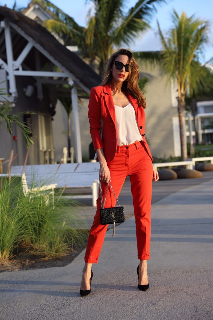 Model & Blogger Alexandra Lapp in Red Vibes wearing a red suit from Airfield, a white silk top from Jadicted, Christian Louboutin black suede pumps, a small Kate Tassel Yves Saint Laurent handbag in black and black Céline sunglasses.