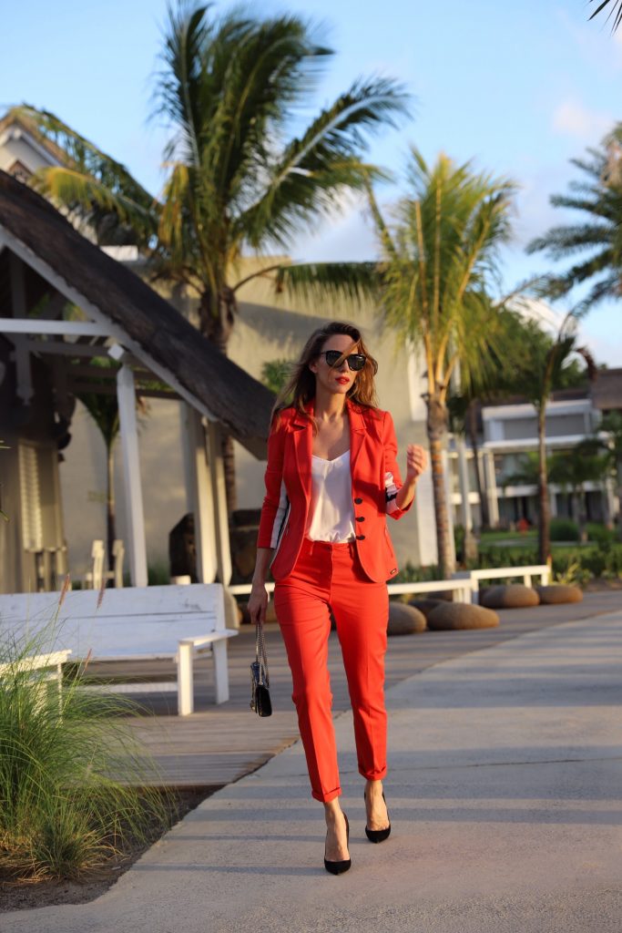 Model & Blogger Alexandra Lapp in Red Vibes wearing a red suit from Airfield, a white silk top from Jadicted, Christian Louboutin black suede pumps, a small Kate Tassel Yves Saint Laurent handbag in black and black Céline sunglasses.