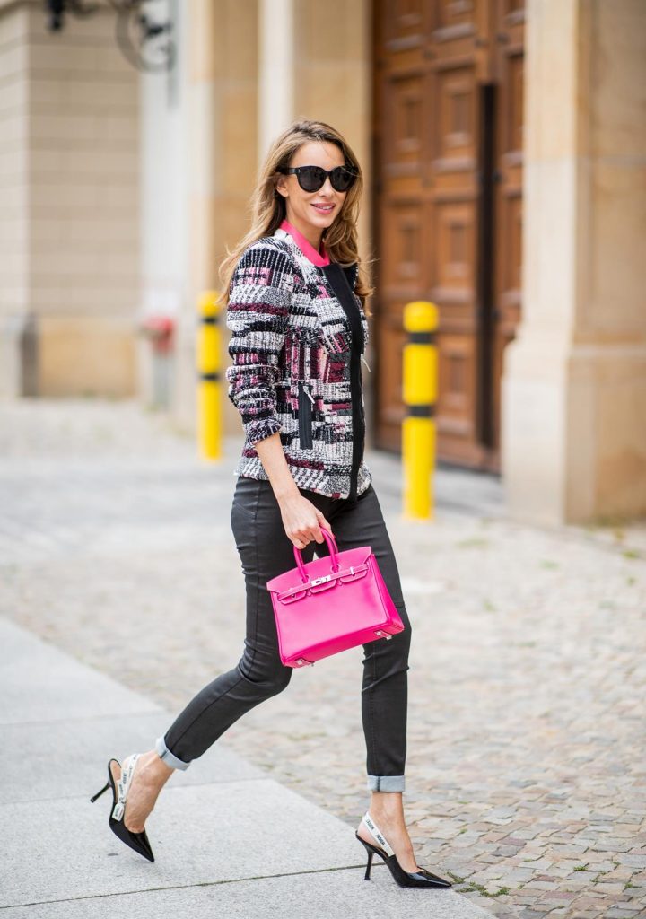 Alexandra Lapp in Birkin Bag Mini Look wearing a short checked colorful jacket with zipper from Airfield, transparent pink blouse with a big flower around the neck from Gucci, black Jeggins by Airfield, Dior slingback pumps in black with a J adior ribbon, a pink mini Birkin bag from Hermes, black Celine sunglasses and IWC watch during the Berlin Fashion Week July 2018 on July 6, 2018 in Berlin, Germany.