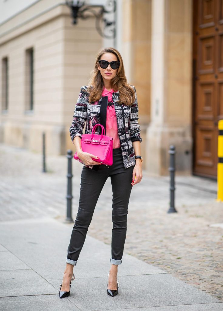 Alexandra Lapp in Birkin Bag Mini Look wearing a short checked colorful jacket with zipper from Airfield, transparent pink blouse with a big flower around the neck from Gucci, black Jeggins by Airfield, Dior slingback pumps in black with a J adior ribbon, a pink mini Birkin bag from Hermes, black Celine sunglasses and IWC watch during the Berlin Fashion Week July 2018 on July 6, 2018 in Berlin, Germany.