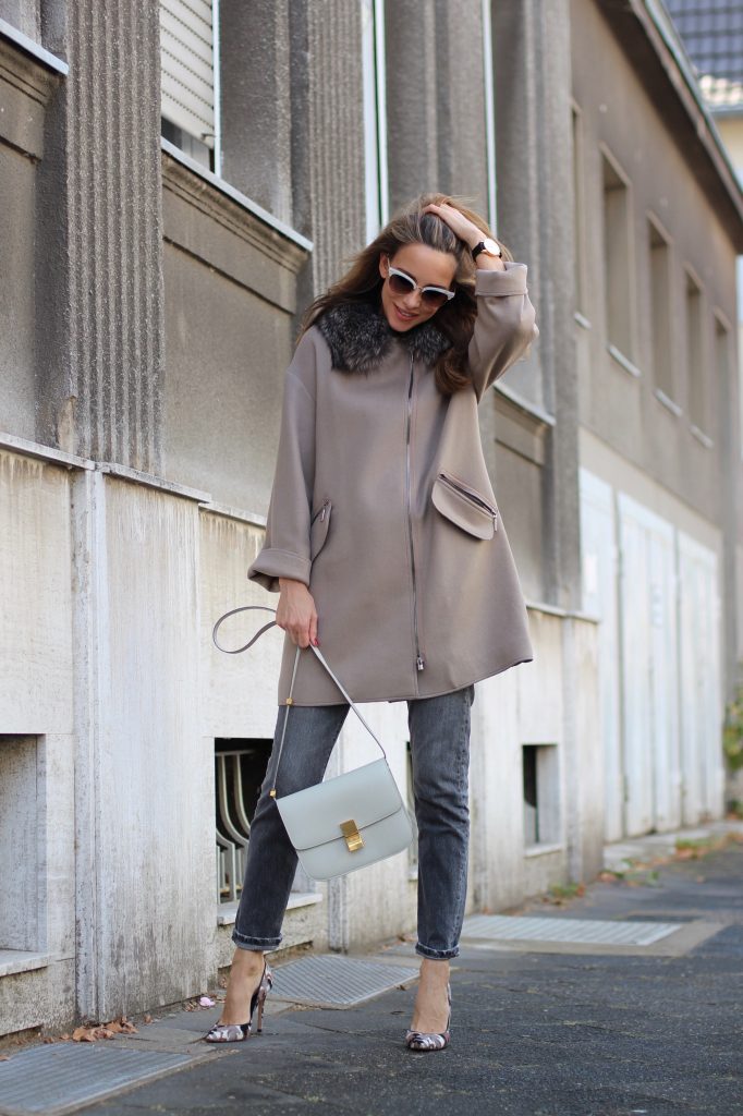 Model and Blogger Alexandra Lapp wearing a Céline Box Bag Look with a wool coat with fur collar in taupe, a light white wool sweater by Zara, grey Levi’s jeans, camouflage Gianvito Rossi pumps, vintage Gucci sunglasses and a light grey Céline box bag in Düsseldorf, Germany.