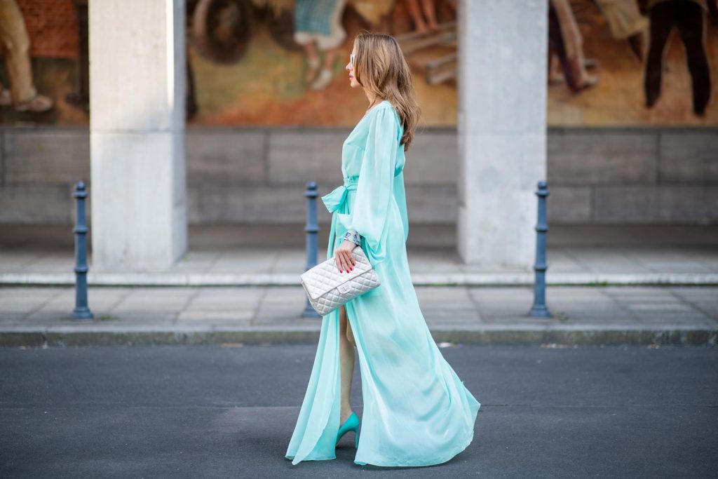 Alexandra Lapp in a turquoise dress wearing a long shine through dress in turquoise by Lana Mueller, a 2.55 silver handbag by Chanel, two tone Manolo Blahnik heels in silver turquoise and white Victoire sunglasses by Saint Laurent seen outside Lana Mueller during the Berlin Fashion Week July 2018 on July 5, 2018 in Berlin, Germany.