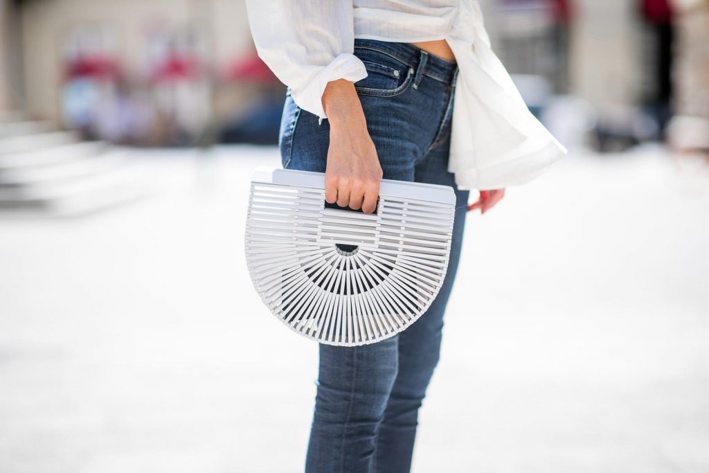 Alexandra Lapp in a Headband Style wearing La Chemise Olhao in off white by Jacquemus, blue AG Adriano Goldschmied denim, white Inez leather sandals by Saint Laurent, white Gaia's Ark bag by Cult Gaia, white Saint Laurent New Wave 213 Lily Sunglasses and a vintage Dior headband during the Berlin Fashion Week July 2018 on July 6, 2018 in Berlin, Germany.