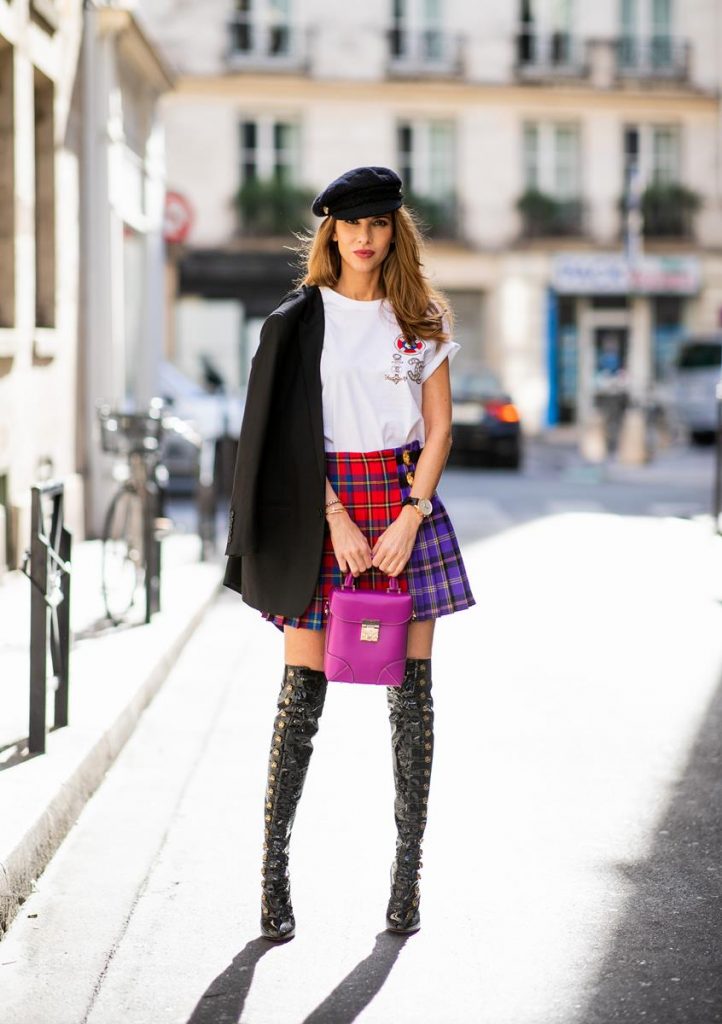 Alexandra Lapp in a Kilt Skirt Look wearing a long black boyfriend oversized blazer by Saint Laurent, a handmade Wodka Ogurez T-Shirt with a hand-painted print, a pleated patchwork tartan mini wool skirt from Versace, Frenchissima Alta Overknees in patent soft black leather by Christian Louboutin, Soft Berlin Crossbody Bag in Viva Lilac from MCM, vintage Chanel bakerboy cap in black and Neenah sunglasses from State Optical in black white is seen during Paris Fashion Week Womenswear Spring/Summer 2019 on September 29, 2018 in Paris, France.