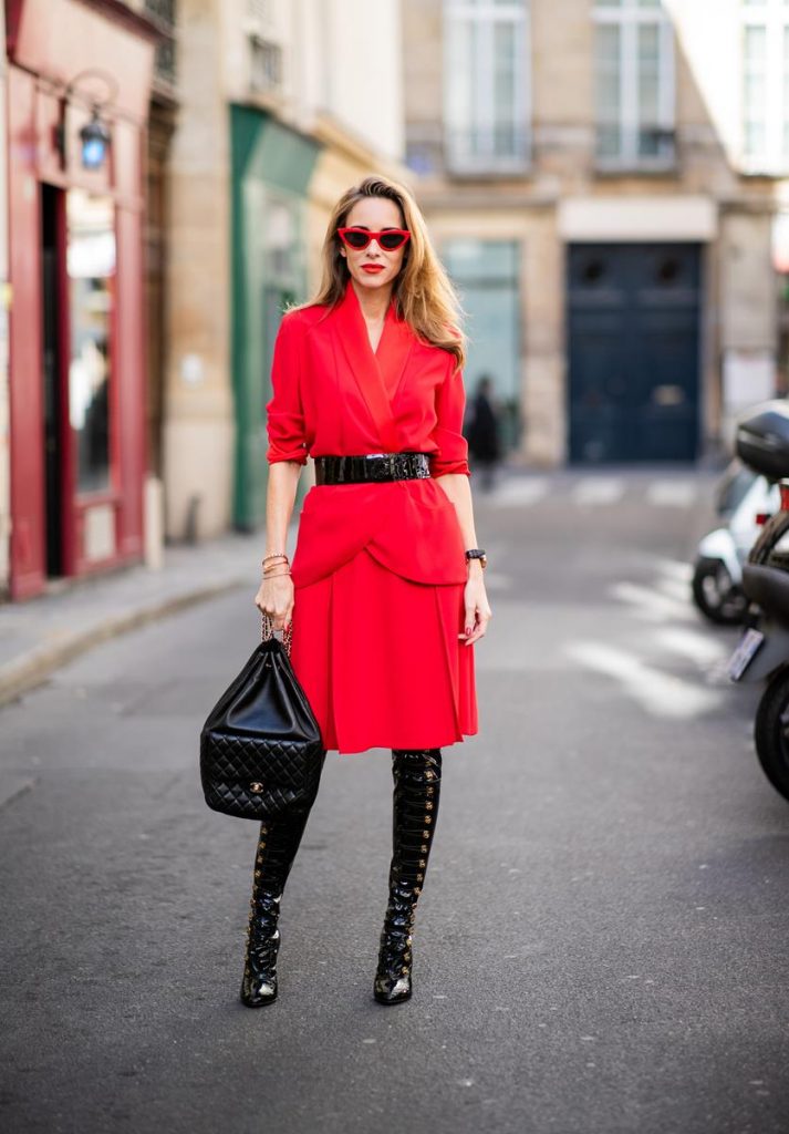 Alexandra Lapp in a Vinyl Overknee Boots Look wearing a long waisted blazer in red by Steffen Schraut, red high waist skirt with attached ribbon by Steffen Schraut, black patent leather waist belt by Gucci, Frenchissima Alta Overknees in patent soft black leather by Christian Louboutin, vintage Chanel backpack in black and red cat-eyed sunglasses by Céline during Paris Fashion Week Womenswear Spring/Summer 2019 on September 24, 2018 in Paris, France.