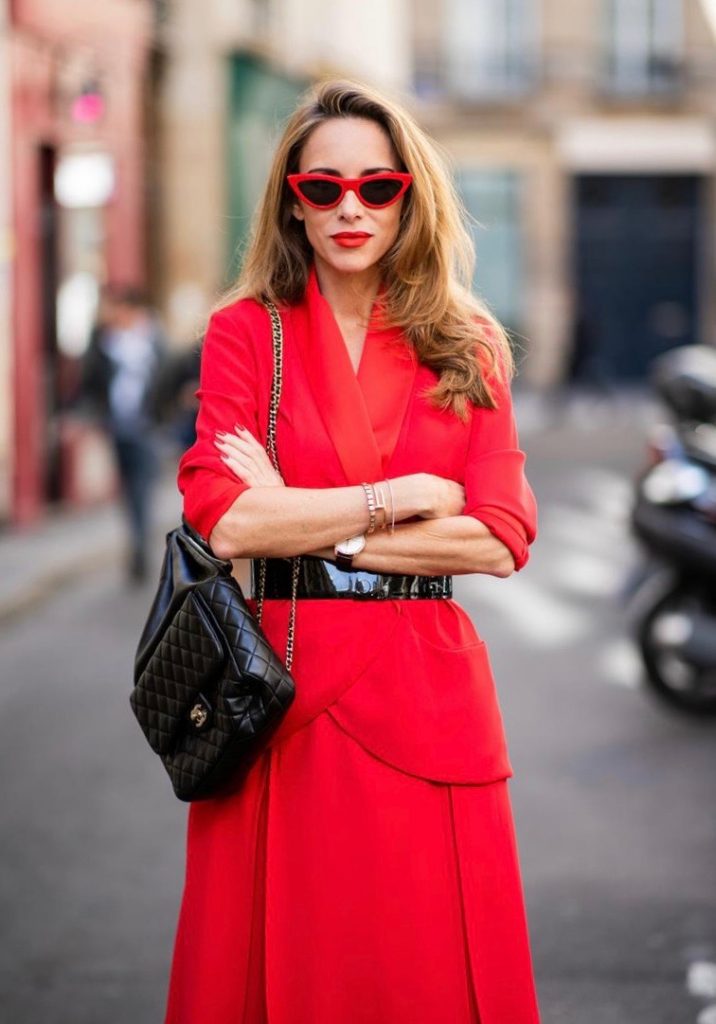 Alexandra Lapp in a Vinyl Overknee Boots Look wearing a long waisted blazer in red by Steffen Schraut, red high waist skirt with attached ribbon by Steffen Schraut, black patent leather waist belt by Gucci, Frenchissima Alta Overknees in patent soft black leather by Christian Louboutin, vintage Chanel backpack in black and red cat-eyed sunglasses by Céline during Paris Fashion Week Womenswear Spring/Summer 2019 on September 24, 2018 in Paris, France.