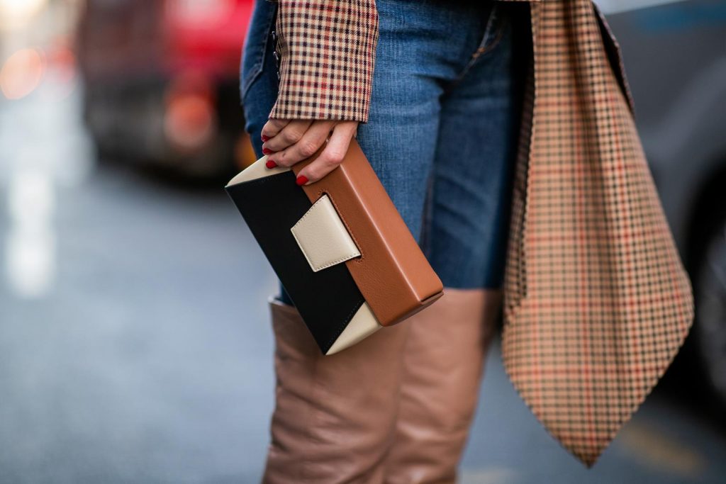 Alexandra Lapp wearing an Off-Shoulder Blazer Look with a plaid asymmetric off shoulder blazer from Monse, dark blue jeans from Rag & Bone, over knee boots in soft pink from Santoni, a Yuzefi Lola leather belt bag in brownish and black tones and brown sunglasses from State Optical during Paris Fashion Week Womenswear Spring/Summer 2019 on September 26, 2018 in Paris, France.