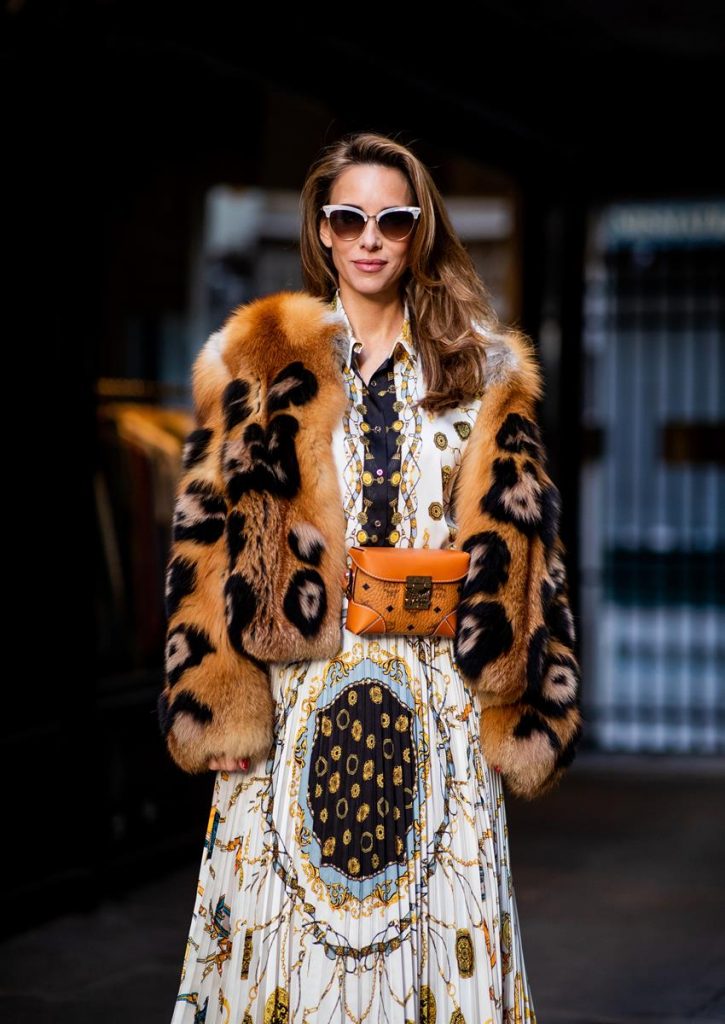 Alexandra Lapp in a Pattern Mix wearing a pleating chain patchwork print skirt and a matching shirt from Zara, a short fur jacket from Yves Salomon with an animal print, Metrisandal open-toe sandals from Christian Louboutin with tape-style straps, the Soft Berlin Belt Bag in Visetos by MCM in cognac and the Gucci cat-eye radiant ivory sunglasses during Paris Fashion Week Womenswear Spring/Summer 2019 on September 24, 2018 in Paris, France.
