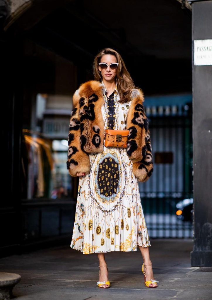 Alexandra Lapp in a Pattern Mix wearing a pleating chain patchwork print skirt and a matching shirt from Zara, a short fur jacket from Yves Salomon with an animal print, Metrisandal open-toe sandals from Christian Louboutin with tape-style straps, the Soft Berlin Belt Bag in Visetos by MCM in cognac and the Gucci cat-eye radiant ivory sunglasses during Paris Fashion Week Womenswear Spring/Summer 2019 on September 24, 2018 in Paris, France.