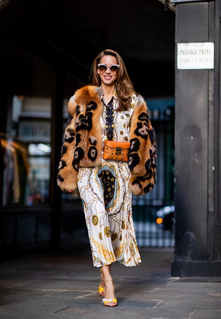 Alexandra Lapp in a Pattern Mix wearing a pleating chain patchwork print skirt and a matching shirt from Zara, a short fur jacket from Yves Salomon with an animal print, Metrisandal open-toe sandals from Christian Louboutin with tape-style straps, the Soft Berlin Belt Bag in Visetos by MCM in cognac and the Gucci cat-eye radiant ivory sunglasses during Paris Fashion Week Womenswear Spring/Summer 2019 on September 24, 2018 in Paris, France.