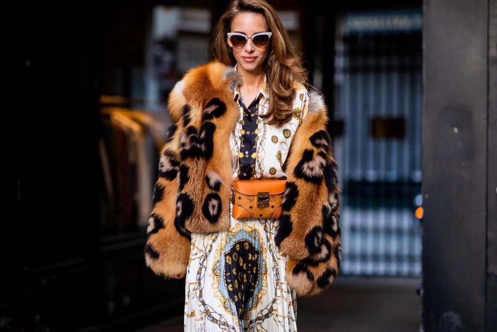 Alexandra Lapp in a Pattern Mix wearing a pleating chain patchwork print skirt and a matching shirt from Zara, a short fur jacket from Yves Salomon with an animal print, Metrisandal open-toe sandals from Christian Louboutin with tape-style straps, the Soft Berlin Belt Bag in Visetos by MCM in cognac and the Gucci cat-eye radiant ivory sunglasses during Paris Fashion Week Womenswear Spring/Summer 2019 on September 24, 2018 in Paris, France.