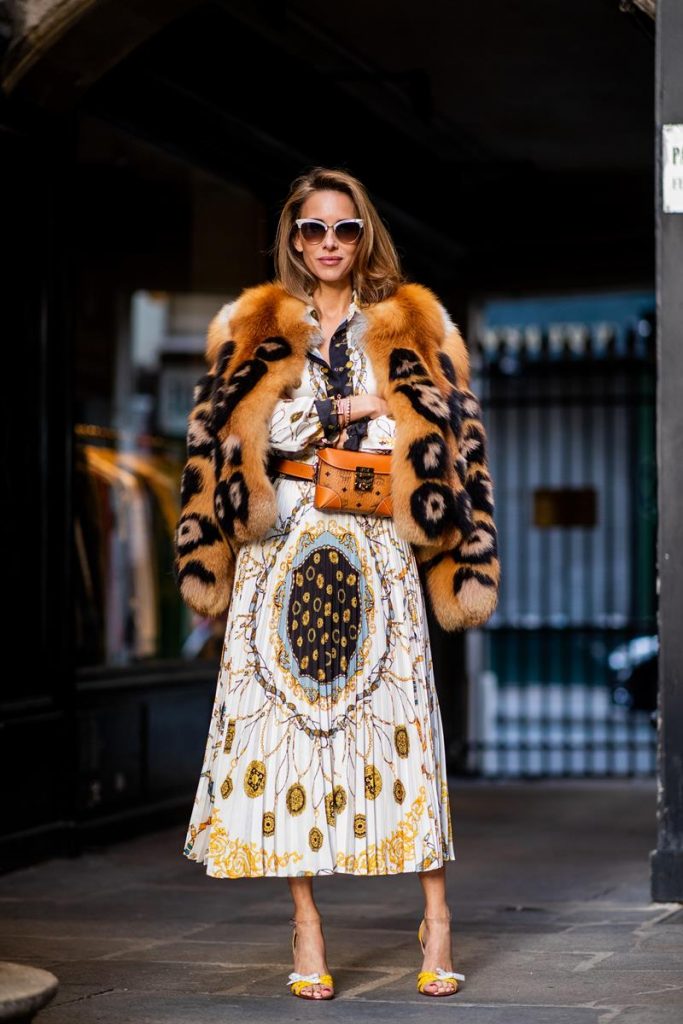 Alexandra Lapp in a Pattern Mix wearing a pleating chain patchwork print skirt and a matching shirt from Zara, a short fur jacket from Yves Salomon with an animal print, Metrisandal open-toe sandals from Christian Louboutin with tape-style straps, the Soft Berlin Belt Bag in Visetos by MCM in cognac and the Gucci cat-eye radiant ivory sunglasses during Paris Fashion Week Womenswear Spring/Summer 2019 on September 24, 2018 in Paris, France.