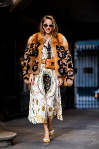 Alexandra Lapp in a Pattern Mix wearing a pleating chain patchwork print skirt and a matching shirt from Zara, a short fur jacket from Yves Salomon with an animal print, Metrisandal open-toe sandals from Christian Louboutin with tape-style straps, the Soft Berlin Belt Bag in Visetos by MCM in cognac and the Gucci cat-eye radiant ivory sunglasses during Paris Fashion Week Womenswear Spring/Summer 2019 on September 24, 2018 in Paris, France.