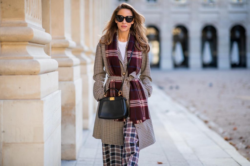 Alexandra Lapp in a Layered Look wearing a plaid oversized coat from SET fashion, a white T-Shirt from Vince, a Glenchek style scarf in dark red tones, wide plaid pants with a long leg in blue and brown tones from Tory Burch, boots in bordeaux from Gianvito Rossi and black Audrey sunglasses from Celine during Paris Fashion Week Womenswear Spring/Summer 2019 on September 27, 2018 in Paris, France.