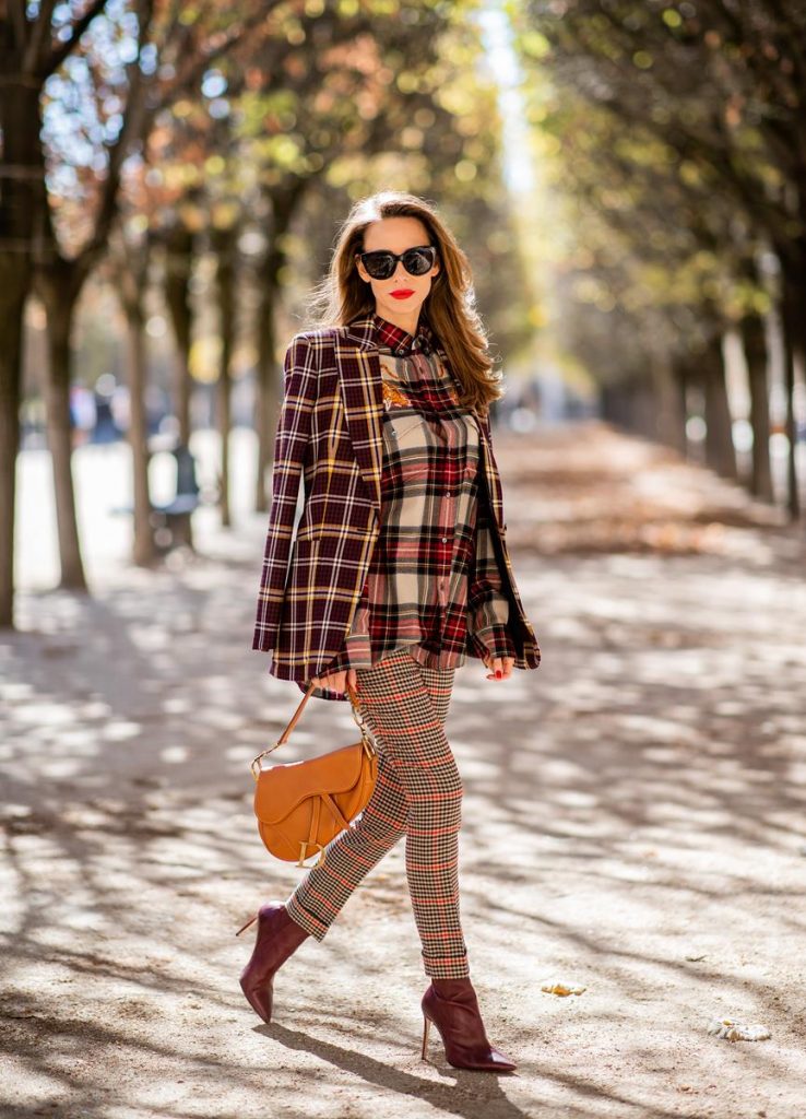 Alexandra Lapp in a Plaid Allover Look is wearing a burgundy and yellow checked wool blazer from Burberry, embroidered checked oversized shirt in red, black, white by Gucci, multi-coloured high-waisted checked trousers from P.A.R.O.S.H., browny embossed leather belt by Max Mara, a vintage Dior saddle bag in cognac, purple Gianvito Rosso boots and black Audrey sunglasses by Celine during Paris Fashion Week Womenswear Spring/Summer 2019 on September 25, 2018 in Paris, France.