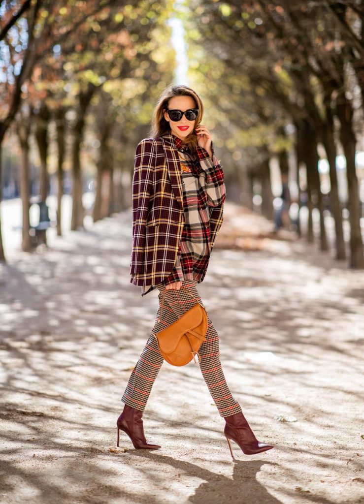 Alexandra Lapp in a Plaid Allover Look is wearing a burgundy and yellow checked wool blazer from Burberry, embroidered checked oversized shirt in red, black, white by Gucci, multi-coloured high-waisted checked trousers from P.A.R.O.S.H., browny embossed leather belt by Max Mara, a vintage Dior saddle bag in cognac, purple Gianvito Rosso boots and black Audrey sunglasses by Celine during Paris Fashion Week Womenswear Spring/Summer 2019 on September 25, 2018 in Paris, France.